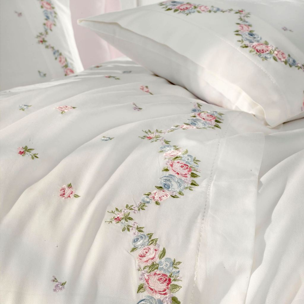Pink, blue, green floral embroideries on white duvet cover makes a combination with pink bed sheet