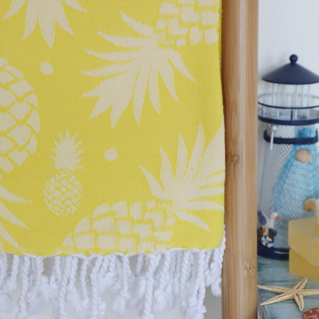 Yellow, pineapple Turkish towel has tassels at the borders