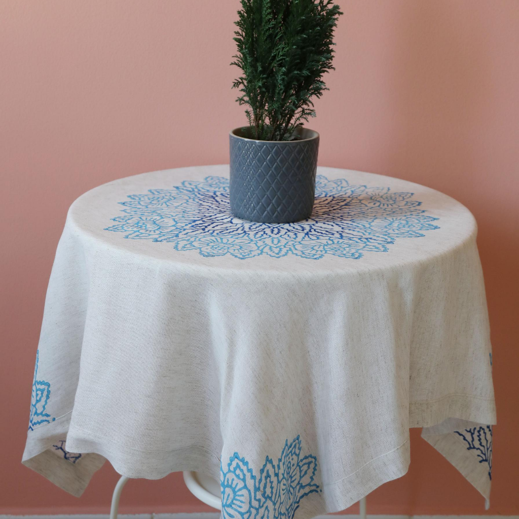 Linen table cloth is hand-crafted with blue, floral designs made by wood-block printing